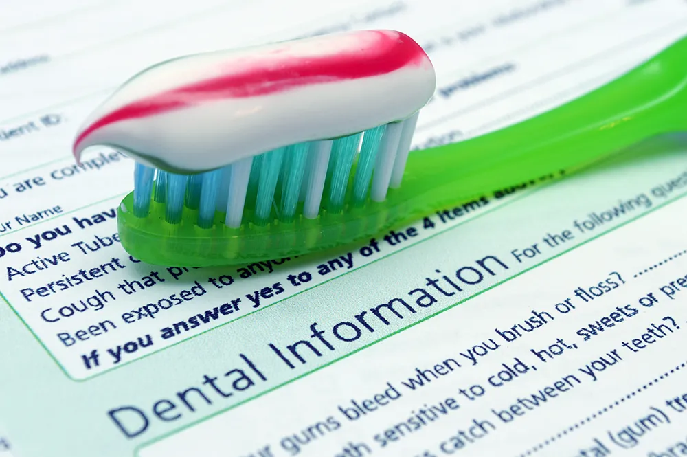 Toothbrush with toothpaste on top of dental forms.