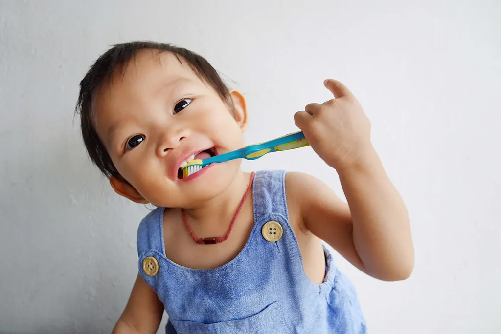 Happy Asian baby girl practice to brushing her teeth.