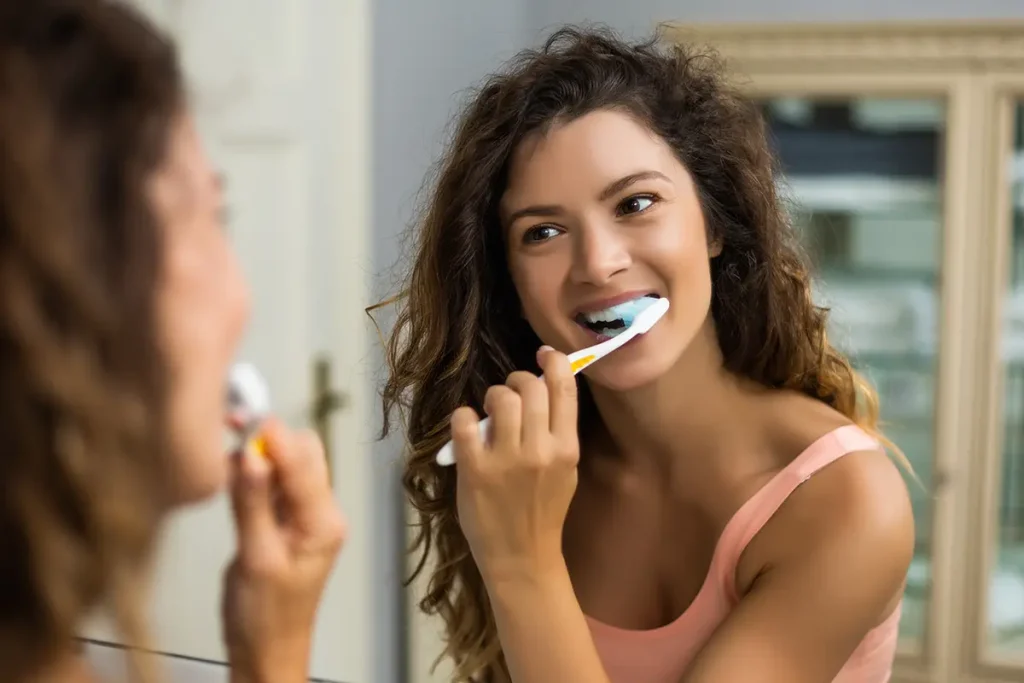 woman brushing teeth in the bathroom.